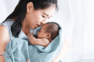Mother holding newborn wrapped in a blanket